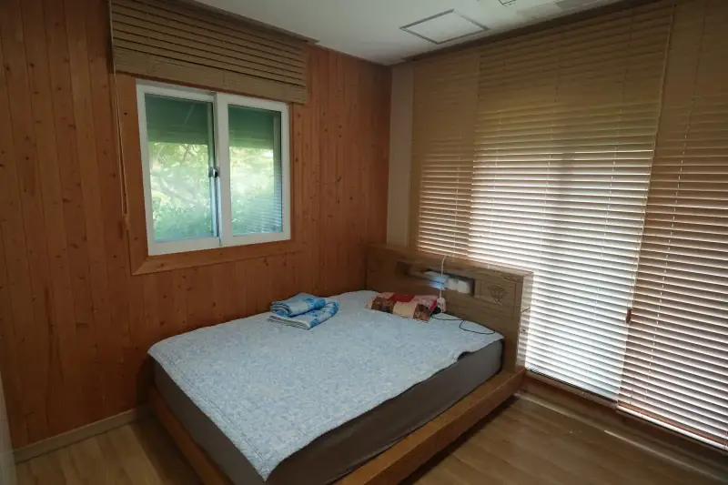 편백 벽과 퀸 침대가 있는 실제 침실